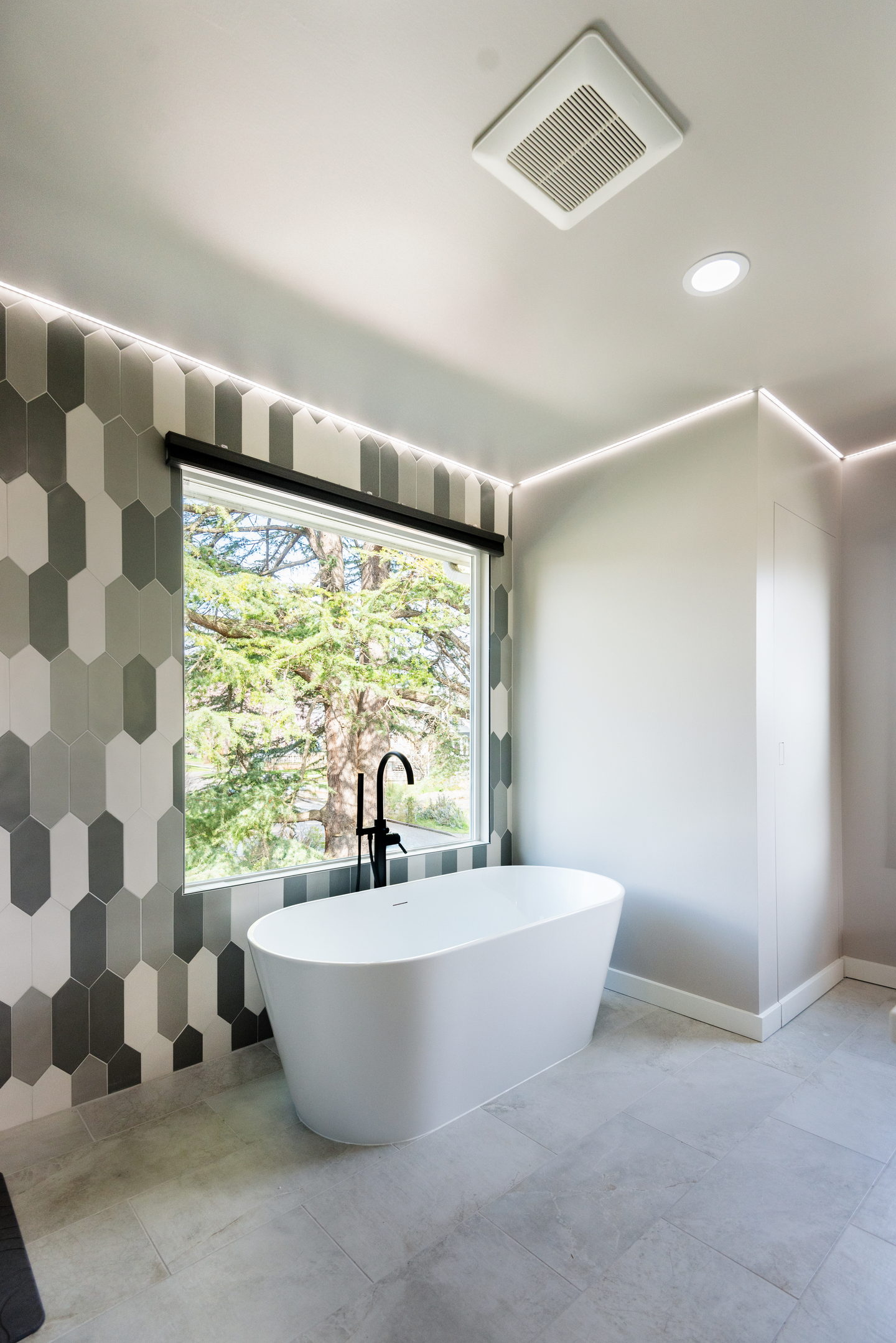 A Ballard primary bathroom seen from the door, with a freestanding tub, tiled shower and double walnut vanity