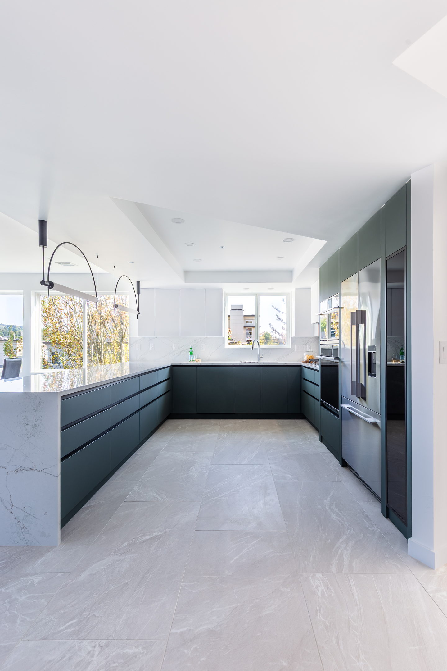 A full condo kitchen with green base units, white uppers and integrated appliances