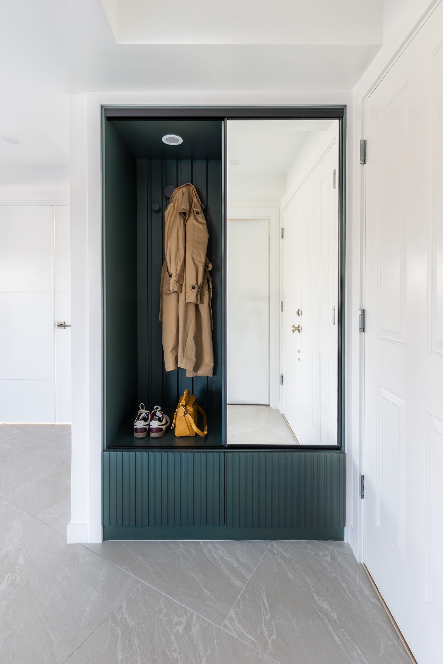 The entry cabinetmaking in fluted green with a full-height mirror