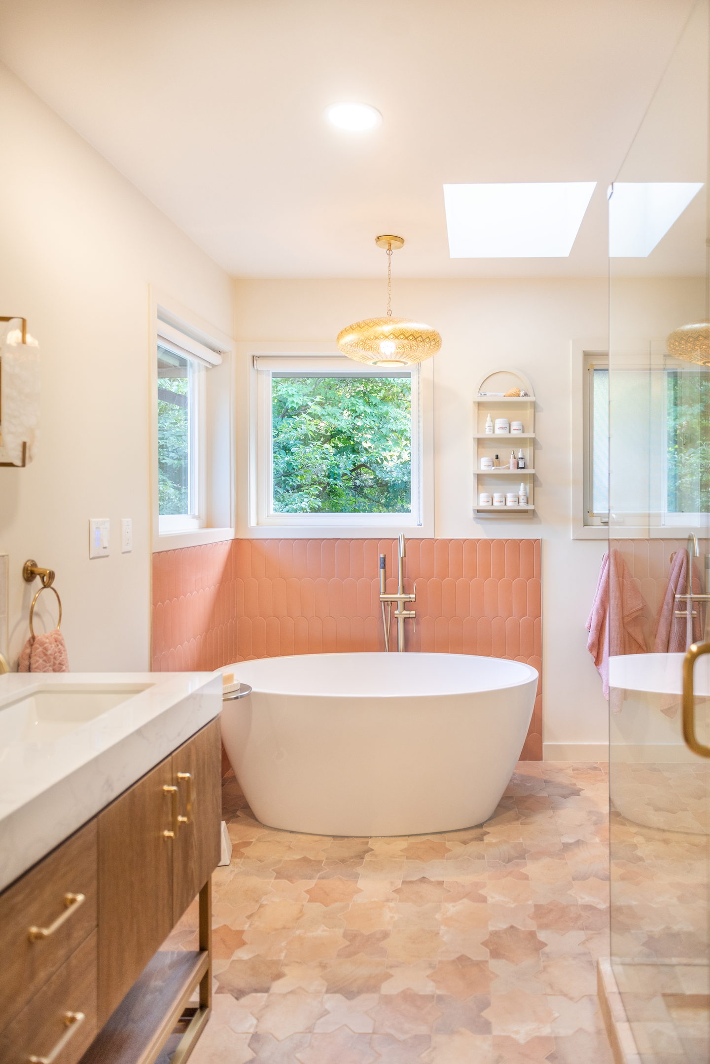 A bathroom with terracotta arched tile, brass and a freestanding tub