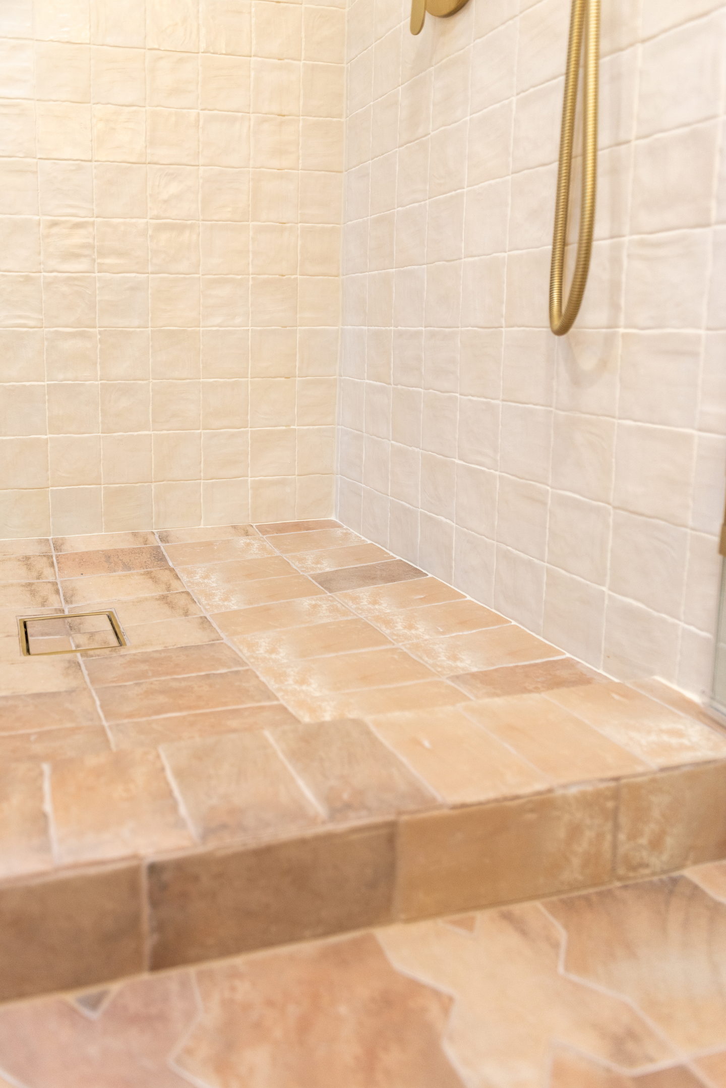 The terracotta shower floor and step, with a brass drain