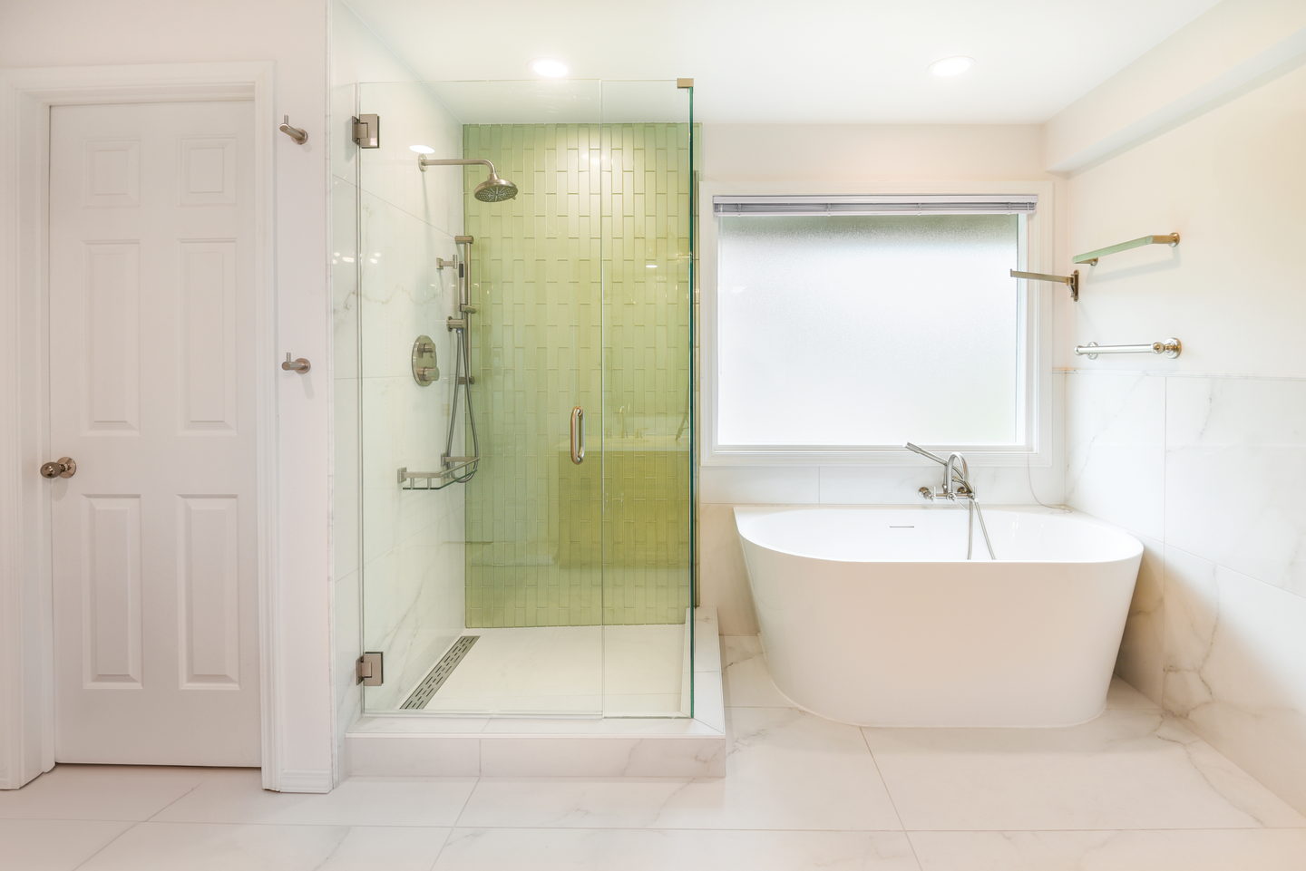 A white bathroom with a wood vanity, glass shower and a large mirror