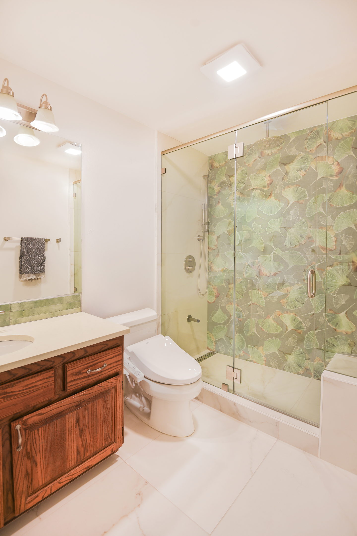 The second Redmond bathroom, with a wood vanity and a glass screen