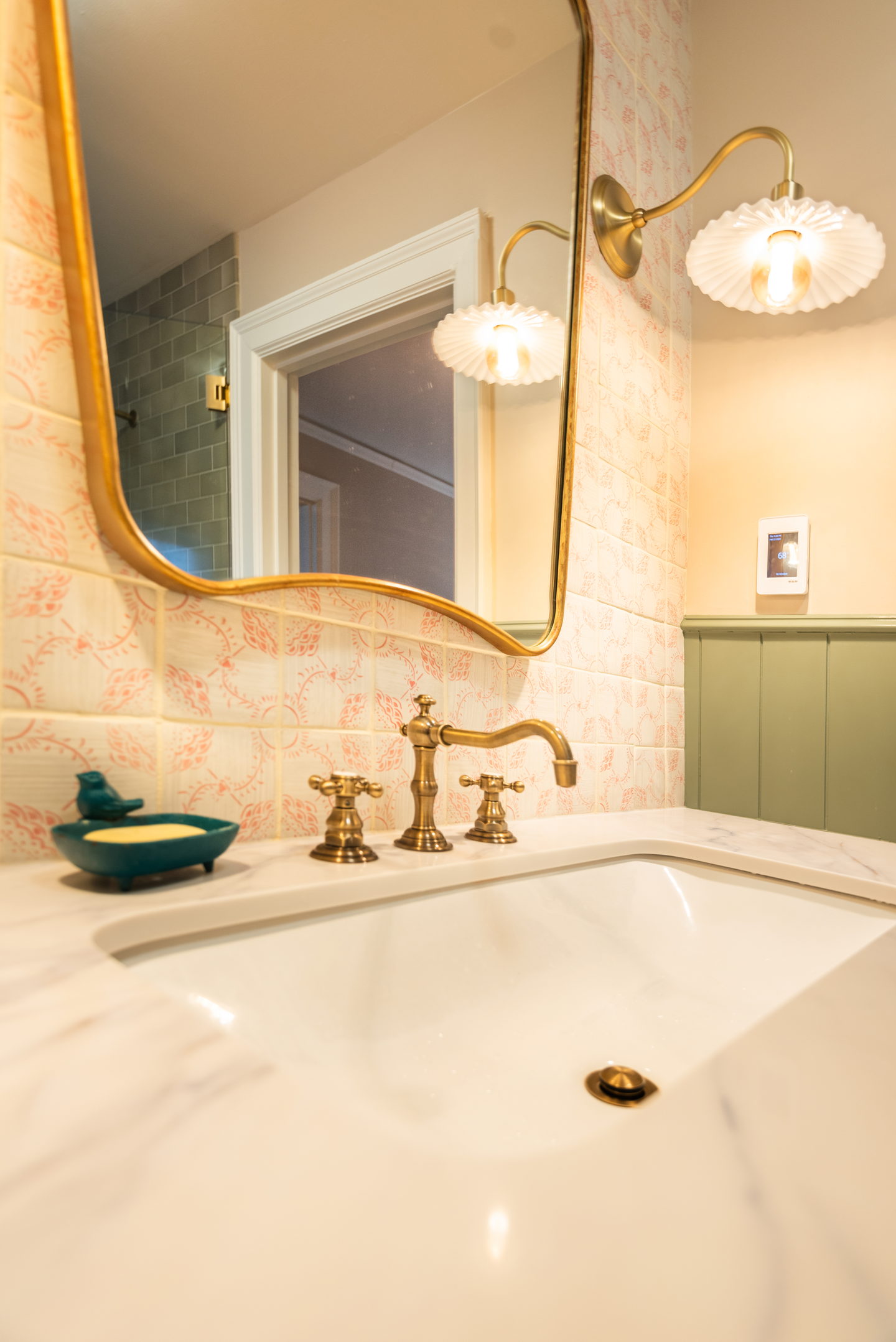 A marble sink surround with an unlacquered brass bridge faucet