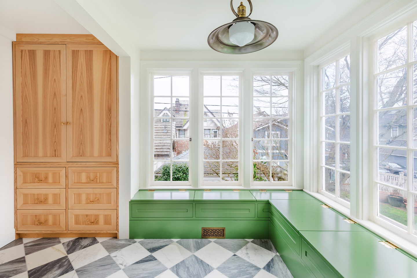 A period kitchen with green painted cabinetry, patterned tile and a checkerboard marble floor