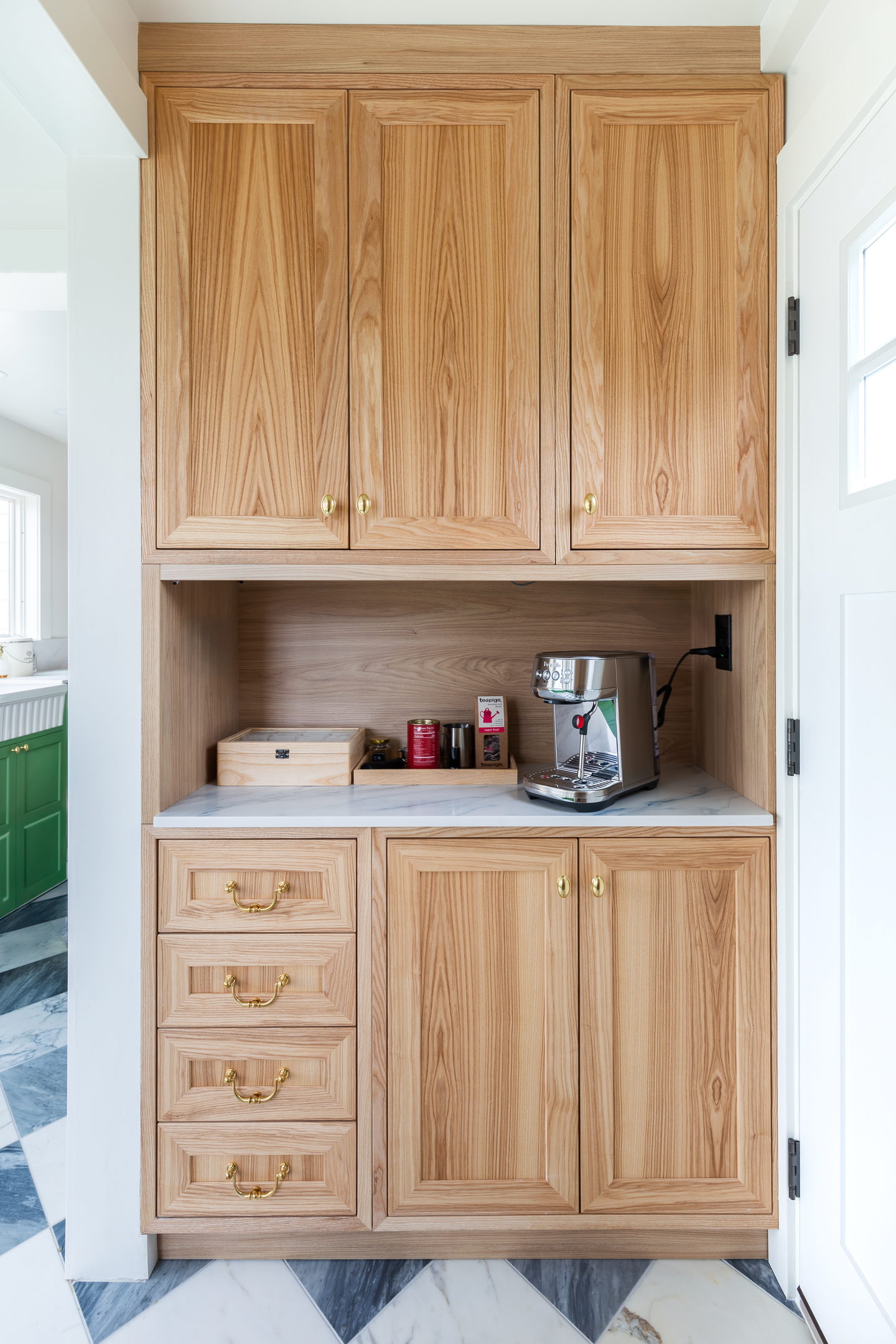 A tall wood pantry cabinet with drawers and an interior countertop