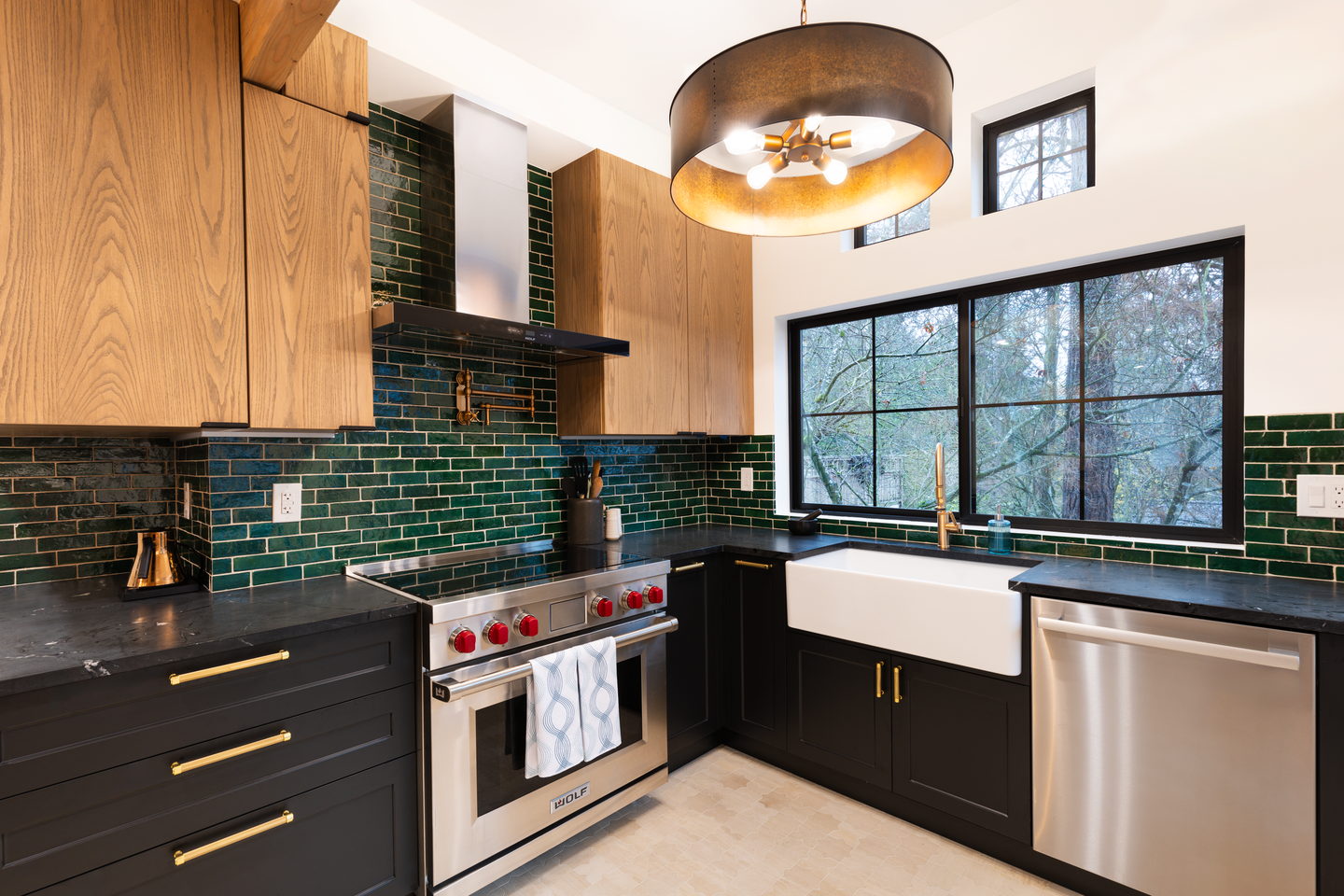 White oak wall cabinets over green tile with an integrated range hood