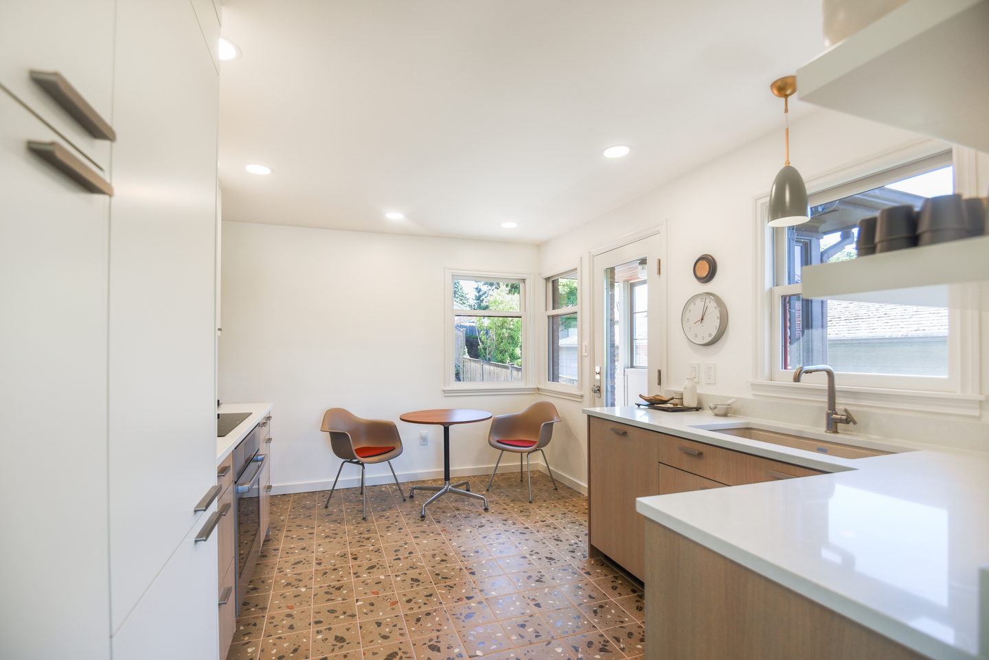 The kitchen seen from the dining table, with a terrazzo floor running through
